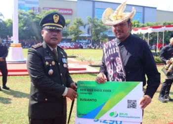 Plt. Kepala Dinas Sosial P3AP2KB Kudu, Satria Agus Himawan(kanan), saat mewakili 9.290 penerima bantuan BPJS Ketenagakerjaan, Minggu, 17 Agustus 2025. (Mohammad Fahtur/Lingkarjateng.id)