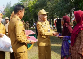 Bupati Kendal, Dyah Kartika Permanasari, membagikan bendera merah putih kepada warga di Alun-alun Kendal pada Senin, 11 Agustus 2025. (Arvian Maulana/Lingkarjateng.id)