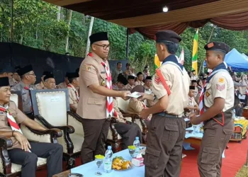 Jalan Kaki ke Sekolah, 2 Siswa di Batang Dapat Hadiah Sepatu dari Bupati Faiz 28 Bupati Batang, M. Faiz Kurniawan, memberikan hadiah sepatu kepada dua siswa dalam upacara peringatan Hari Gerakan Pramuka ke-64 di Lapangan Kedungmalang, Wonotunggal, Kabupaten Batang, pada Kamis, 14 Agustus 2025. (Pemkab Batang/Lingkarjateng.id)