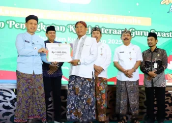 Bupati Kudus, Sam'ani Intakoris (kiri) saat menyerahkan secara simbolis bantuan program HKGS kepada guru swasta beberapa waktu lalu. (Nisa Hafizhotus S./Lingkarjateng.id)