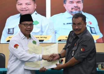 Ketua Bawaslu Salatiga Dayusman Junus berjabat tangan dengan Dekan Fakultas Dakwah UIN Adang Kuswaya usai menjalin kerja sama dengan pihak kampus tersebut, Senin, 4 Agustus 2025. (Dok. Bawaslu Salatiga)