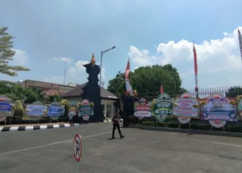 POTRET: Seorang warga tengah melintas di antara puluhan karangan bunga yang dipasang berjajar mengelilingi pagar depan Pendopo Kabupaten Kudus, Jawa Tengah, Kamis, 4 September 2025. (Antara/Lingkar.news)