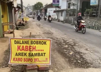 Warga memasang spanduk sebagai aksi protes atas rusaknya jalan di Desa Wringin Putih, Kecamatan Bergas, Kabupaten Semarang. (Hesty Imaniar/Lingkarjateng.id)