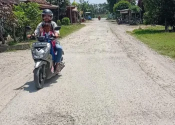 POTRET: Pengendara motor melewati Jalan Desa Pelem-Jati, Kecamatan Jati, Kabupaten Blora. (Hanafi/Lingkarjateng.id)
