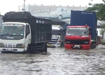 Kendaraan menerjang banjir di salah satu jalan di Kota Semarang, Kamis, 23 Oktober 2025. (Syahril Muadz/Lingkarjateng.id)