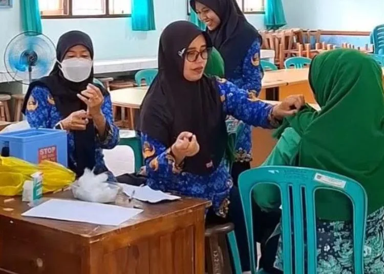 Eliminasi Kanker Serviks, Dinkes Rembang Gencar Imunisasi HPV ke Siswi Sekolah 25 ILUSTRASI: Petugas Dinas Kesehatan Kabupaten Rembang menyuntikkan vaksin HPV kepada pasien. (Muhammad Faalih/Lingkarjateng.id)