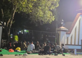 Puluhan relawan dari Aliansi Masyarakat Pati Bersatu (AMPB) menggelar tikar di depan Mapolresta Pati pada Jumat malam, 3 Oktober 2025 sebagai bentuk pengawalan agar kasus intimidasi segera diusut. (Dok. for Lingkarjateng.id)
