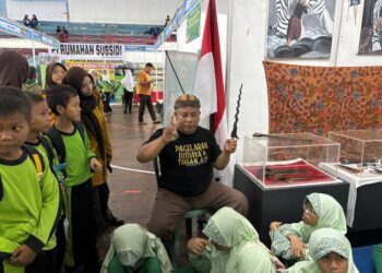 Penjaga Museum Keris Kota Pekalongan, Rifqon Arodli, menunjukkan salah satu koleksi keris kepada para pelajar dalam Festival Literasi Kota Pekalongan, Sabtu, 8 November 2025. (Fahri Akbar/Lingkarjateng.id)