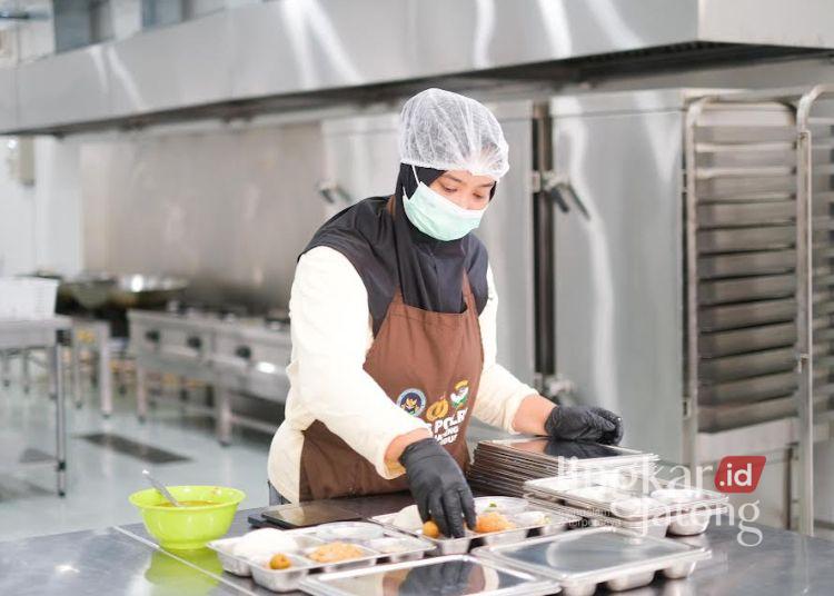 Seluruh SPPG di Kudus Ditarget Beroperasi Layani Program MBG 2026 25 ILUSTRASI: Salah satu petugas Satuan Pelayanan Pemenuhan Gizi (SPPG) Polri menyiapkan makanan untuk progam makan bergizi gratis. (Nisa Hafizhotus Syarifa/Lingkarjateng.id)