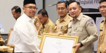 Bupati Batang, M. Faiz Kurniawan, menyerahkan piagam penghargaan kepada Pelaksana Tugas Kepala Dinas Kominfo Kabupaten Batang, Wawan Nurdiansyah, di Batang, Selasa, 2 Desember 2025. (Antara/Lingkarjateng.id)