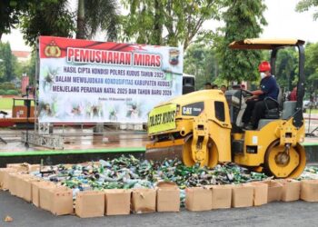 Petugas memusnahkan ribuan botol miras di Alun-alun Simpang Tujuh Kudus, Jumat, 19 Desember 2025. (Nisa Hafizhotus Syarifa/Lingkarjateng.id)