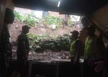 Petugas kepolisian bersama warga setempat meninjau dan membersihkan material longsor di lokasi rumah warga Dukuh Mendolo Wetan yang terdampak hujan deras, Kamis, 25 Desember 2025. (Polsek Lebak Barang/Lingkarjateng.id)
