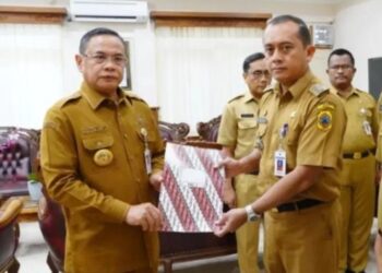 Bupati Pati Sudewo (kiri) menyerahkan SK pengangkatan pejabat kepada Tony Romas sebagai kepala Dinas Perhubungan pada Senin, 22 Desember 2025. (Lingkarnews Network)