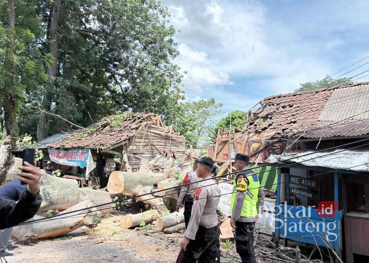 Pohon Randu Berusia 100 Tahun di Pekalongan Tumbang Timpa Warung, Dua Orang Terluka 25 Petugas gabungan mengevakuasi pohon randu tumbang di Jalan Raya Wonopringgo, Desa Rowokembu, Kecamatan Wonopringgo, Kabupaten Pekalongan, Selasa siang, 16 Desember 2025. (Fahri Akbar/Lingkarjateng.id)