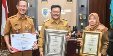 Salatiga Raih Tiga Penghargaan Bidang Kesehatan, Wali Kota Apresiasi Dinkes 10 Wali Kota Salatiga Robby Hernawan (tengah) menunjukan piagam penghargaan dari Menkes di ruang kerjanya, Senin, 15 Desember 2025. (Dok. Prokompim Setda Salatiga/Lingkarjateng.id)