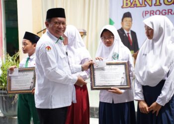 Wakil Ketua Komisi VIII DPR RI, Abdul Wachid, saat menyerahkan bantuan PIP secara simbolis kepada siswa di MI Miftahul Huda Bonangrejo, Kecamatan Bonang, Kabupaten Demak, Senin, 15 Desember 2025. (M. Burhanuddin Aslam/Lingkarjateng.id)