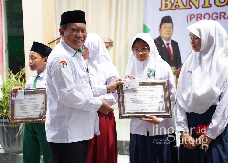 12.200 Siswa Madrasah di Demak Dapat Bantuan Program Indonesia Pintar 25 Wakil Ketua Komisi VIII DPR RI, Abdul Wachid, saat menyerahkan bantuan PIP secara simbolis kepada siswa di MI Miftahul Huda Bonangrejo, Kecamatan Bonang, Kabupaten Demak, Senin, 15 Desember 2025. (M. Burhanuddin Aslam/Lingkarjateng.id)