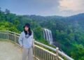 Salah satu pengunjung berfoto dengan latar air terjun Curug Sewu Kecamatan Patean, Kabupaten Kendal. (Dokumentasi untuk Lingkarjateng.id)