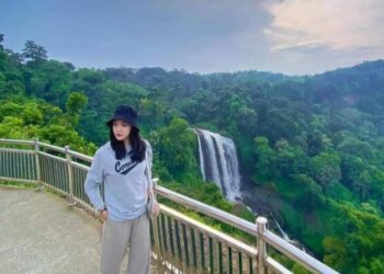 Salah satu pengunjung berfoto dengan latar air terjun Curug Sewu Kecamatan Patean, Kabupaten Kendal. (Dokumentasi untuk Lingkarjateng.id)
