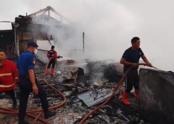 Petugas Pemadam Kebakaran saat melakukan pemadaman sisa sisa api yang membakar toko material dan penggilingan padi di Desa Kramat RT 02 RW 01, Kecamatan Dempet, Kabupaten Demak, Senin, 22 Desember 2025. (Burhanuddin Aslam/Lingkarjateng.id)