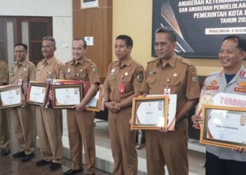 Staf Ahli Bidang Pembangunan Ekonomi dan Keuangan Kota Pekalongan, Sri Budi Santoso foto bersama penerima penghargaan Anugerah KIP dan Pengelolaan Pengaduan Publik 2025 di Ruang Buketan Setda Kota Pekalongan, Senin, 8 Desember 2025. (Fahri Akbar/Lingkarjateng.id)
