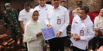 Bupati Jepara, Witiarso Utomo, saat menyerahkan bantuan perbaikan rumah terdampak bencana di Desa Welahan, Kecamatan Welahan, Rabu, 28 Januari 2026. (Tomi Budianto/Lingkarjateng.id)