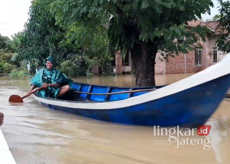Bupati Pati Minta Dukungan Pemerintah Pusat Tangani Bencana 25 Warga menggunakan perahu sebagai alat mobilitas lantaran banjir melanda di Desa Mintobasuki, Kecamatan Gabus, Kabupaten Pati pada Jumat, 16 Januari 2026. (Lingkarnews Network)