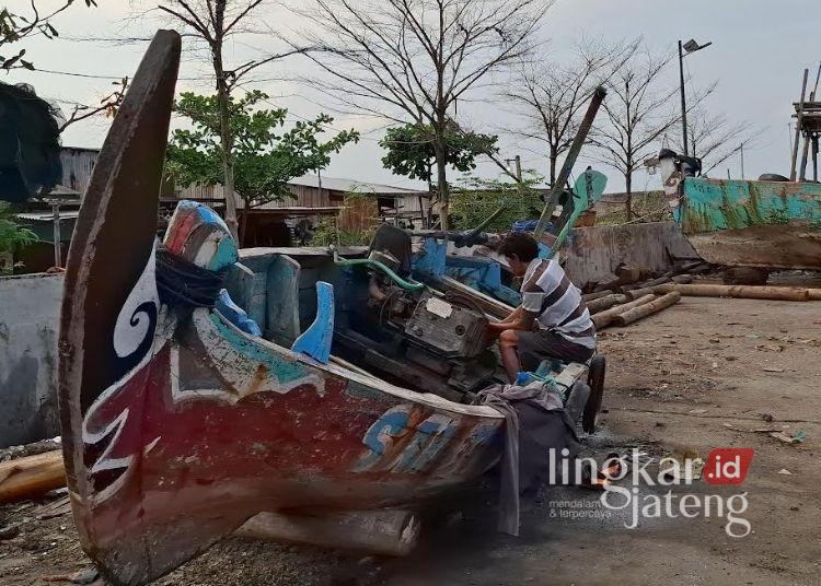 Hasil Nelayan di Semarang Minim Imbas Cuaca Ekstrem-Proyek Tol Tanggul Laut 25 Seorang nelayan, Kusrianto, memperbaiki mesin perahu di pinggir tanggul laut Tambak Lorok, Kelurahan Tanjung Emas, Kota Semarang, Selasa, 6 Juni 2026. (Syahril Muadz/Lingkarjateng.id)