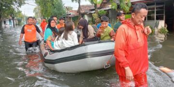 Tim BPBD Kota Pekalongan mengevakuasi warga terdampak banjir menggunakan perahu karet di wilayah terdampak limpasan Sungai Bremi, Sabtu, 17 Januari 2026. (Fahri Akbar/Lingkarjateng.id)