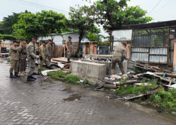 Petugas Satuan Polisi Pamong Praja (Satpol PP) Kota Semarang menertibkan sejumlah lapak PKL yang berdiri di atas saluran drainase di kawasan Pasar Kobong, Kecamatan Semarang Timur, Senin pagi, 12 Januari 2026. (Syahril Muadz/Lingkarjateng.id)