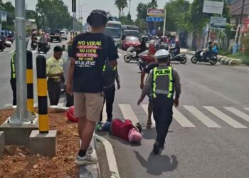 Mobil Tahanan Pembawa Botok dan Teguh Serempet Pengendara Motor di Depan PN Pati 25 Petugas kepolisian hendak mengevakuasi wanita yang terserempet mobil tahanan milik Kejari Pati yang membawa Teguh dan Botok di perempatan depan Kantor Pengadilan Negeri (PN) Pati, Rabu, 7 Januari 2025. (Lingkarnews Network/Lingkarjateng.id)