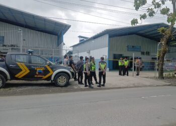 Petugas kepolisian menjaga SPPG Kuwaron usai ratusan siswa dan santri di Kecamatan Gubug diduga keracunan MBG, Jumat, 9 Januari 2026. (Ahmad Abror/Lingkarjateng.id)