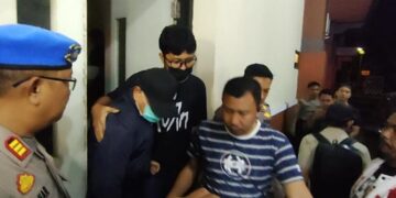 Bupati Pati Sudewo (masker biru) saat hendak masuk mobil menuju ke Kantor KPK Jakarta setelah menjalani pemeriksaan di Polres Kudus pada Senin malam, 19 Januari 2026. (Fahtur Rohman/Lingkarjateng.id)
