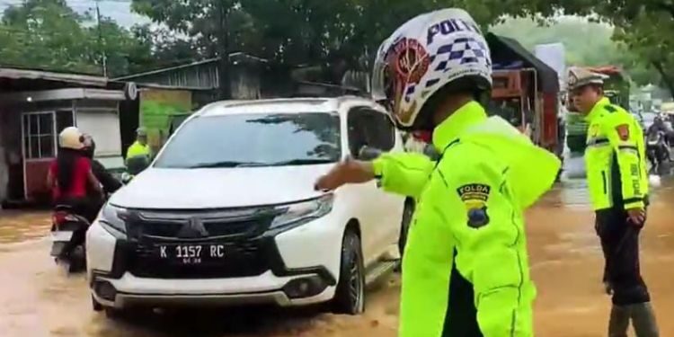 Petugas Satlantas Polresta Pati mengatur arus lalu lintas menuju Pati kota yang tergenang banjir, Senin, 12 Januari 2026. (Lingkarnews Network)