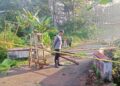 Petugas kepolisian memasang garis polisi di lokasi jembatan ambrol di Dusun Randukuning, Desa Harjosari, Kecamatan Doro, Kabupaten Pekalongan, Jumat, 16 Januari 2026. (Fahri Akbar/Lingkarjateng.id)