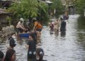 Sungai Sengkarang Meluap, 10 Desa di Kabupaten Pekalongan Terendam Banjir 30 Warga Desa Mulyorejo Kecamatan Tirto melintasi genangan banjir yang merendam permukiman akibat luapan Sungai Sengkarang di Kabupaten Pekalongan, Sabtu, 24 Januari 2026. (Fahri Akbar/Lingkarjateng.id)