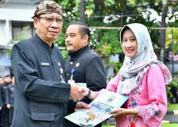 Asisten Administrasi Umum Setda Batang, Sugeng Sudiharto (kiri), menyerahkan SK kenaikan pangkat saat apel pagi di Halaman Pendopo Kabupaten Batang, Senin, 9 Februari 2026. (Humas Pemkab Batang/Lingkarjateng.id)