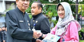 Asisten Administrasi Umum Setda Batang, Sugeng Sudiharto (kiri), menyerahkan SK kenaikan pangkat saat apel pagi di Halaman Pendopo Kabupaten Batang, Senin, 9 Februari 2026. (Humas Pemkab Batang/Lingkarjateng.id)