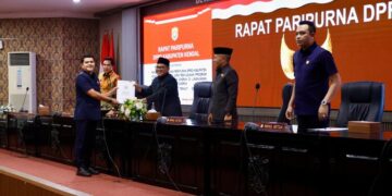 Ketua Pansus IV, Mora Sandhy Purwandono, menyerahkan berkas kepada Ketua DPRD Kendal dalam rapat paripurna, Selasa, 24 Februari 2026. (Arvian Maulana/Lingkarjateng.id)