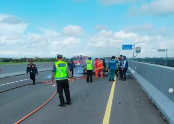 Petugas kepolisian saat melakukan evakuasi serta olah TKP peristiwa mobil terbakar di Jalan Tol Demak-Semarang, Jumat, 6 Februari 2026. (M. Burhanuddin Aslam/Lingkarjateng.id)