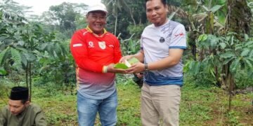 Kepala Dinas Pemberdayaan Masyarakat dan Desa (Dispermasdes) Kabupaten Kendal Yanuar Fatoni menyerahkan tumpeng usai doa bersama dan tasyakuran pembukaan pekerjaan pengeboran sumber air bersih di Dusun Gedong, Desa Gedong, Kecamatan Patean pada Minggu, 15 Februari 2026. (Anik Kustiani/Lingkarjateng.id)