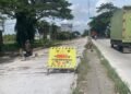 POTRET: ⁠Papan peringatan di titik lokasi perbaikan jalan pantura turut wilayah Trengguli, Kabupaten Demak. (M. Burhanuddin Aslam/Lingkarjateng.id)