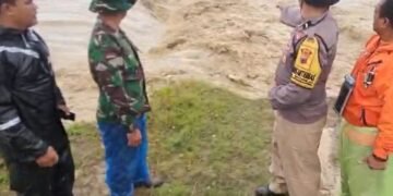 Petugas kepolisian menunjukan titik jebol tanggul Sungai Cabean Dukuh Singopadu, Desa Sidorejo, Kecamatan Karangawen, Kabupaten Demak, jebol pada Senin, 16 Februari 2026. (Dok for Lingkarjateng.id)