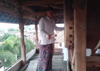 Seorang Santri Menabuh Bedug Di Atas Menara Kudus pada Rabu (18/2) sore. Foto : Fahtur Rohman /Lingkar Jateng