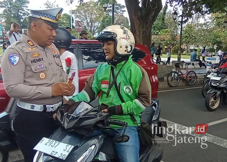 Polres Salatiga Gelar Operasi Keselamatan Candi 2026, Sasar Pelanggaran Ini 25 Kasat Lantas Polres Salatiga AKP Henry Sulistyanta DS memberikan bunga dan coklat kepada pengendara motor yang tertib lalu lintas yang melintas di depan Mapolres, Senin, 2 Februari 2026. (Angga Rosa/Lingkarjateng.id)