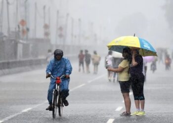Ilustrasi warga menerjang guyuran hujan lebat. (Antara/Lingkarjateng.id)