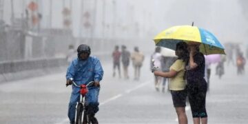 Ilustrasi warga menerjang guyuran hujan lebat. (Antara/Lingkarjateng.id)