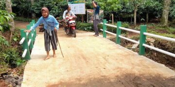 POTRET: Warga melintasi jembatan di Dusun Tempuran, Desa Gedong, Kecamatan Patean, Kabupaten Kendal yang baru selesai dibangun melalui program TMMD Reguler ke-127 tahun 2026. (Anik Kustiani/Lingkarjateng.id)