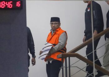 Eks Menteri Agama, Yaqut Cholil Qoumas, memakai rompi oranye berjalan menuju mobil tahanan di Gedung Merah Putih KPK, Jakarta, Kamis, 12 Maret 2026. (Lingkarjateng.id)