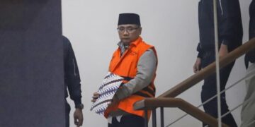 Eks Menteri Agama, Yaqut Cholil Qoumas, memakai rompi oranye berjalan menuju mobil tahanan di Gedung Merah Putih KPK, Jakarta, Kamis, 12 Maret 2026. (Lingkarjateng.id)